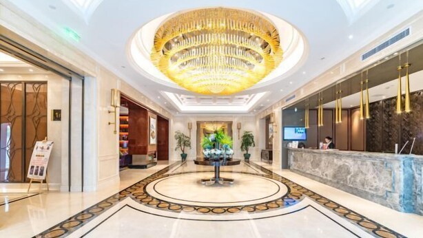 A hotel lobby with a central fountain, a reception desk, and a modern chandelier. - Greentree Eastern Hotel (Jianhu Ouba Liya Life Square) (Jianhu)