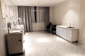A modern bathroom with a large mirror, a sink, and a massage chair. - Greentree Eastern Hotel (Jianhu Ouba Liya Life Square) (Jianhu)