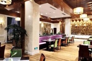 A restaurant with wooden flooring, a bar area, and seating arrangements. - Greentree Eastern Hotel (Jianhu Ouba Liya Life Square) (Jianhu)