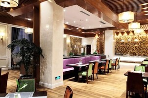 Restaurante com piso de madeira, área de bar e disposição de mesas.