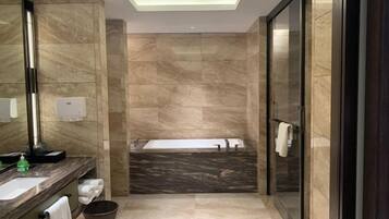 Une salle de bain moderne avec un meuble-lavabo en marbre, un grand miroir, une baignoire et une cabine de douche en verre.