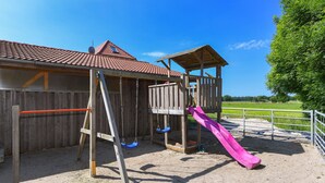 Ein Spielplatz mit einer Rutsche und Schaukeln.