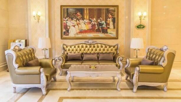 Eine luxuriöse Lobby mit einem großen Gemälde, eleganten Sofas und klassischen Lampen.