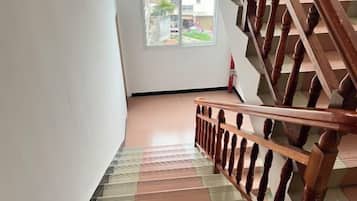A staircase with a wooden handrail and a patterned floor.