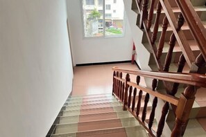 A staircase with a wooden handrail and a patterned floor. - 7 xing Ge Business Hotel (Xing'an County)