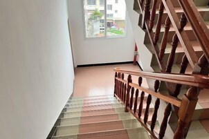 Una escalera con barandilla de madera y suelo estampado.