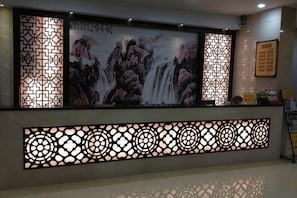 Ein Empfangsbereich mit traditioneller chinesischer Wandverkleidung, einer dekorativen Wand und einer Rezeption.