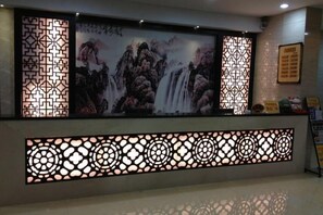 A reception area with a large screen displaying a waterfall painting, decorative screens, and a reception desk. - 7 xing Ge Business Hotel (Xing'an County)