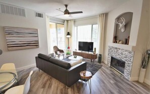 Relax in this stylish living room with a fireplace, flat-screen TV, and comfortable sofa.