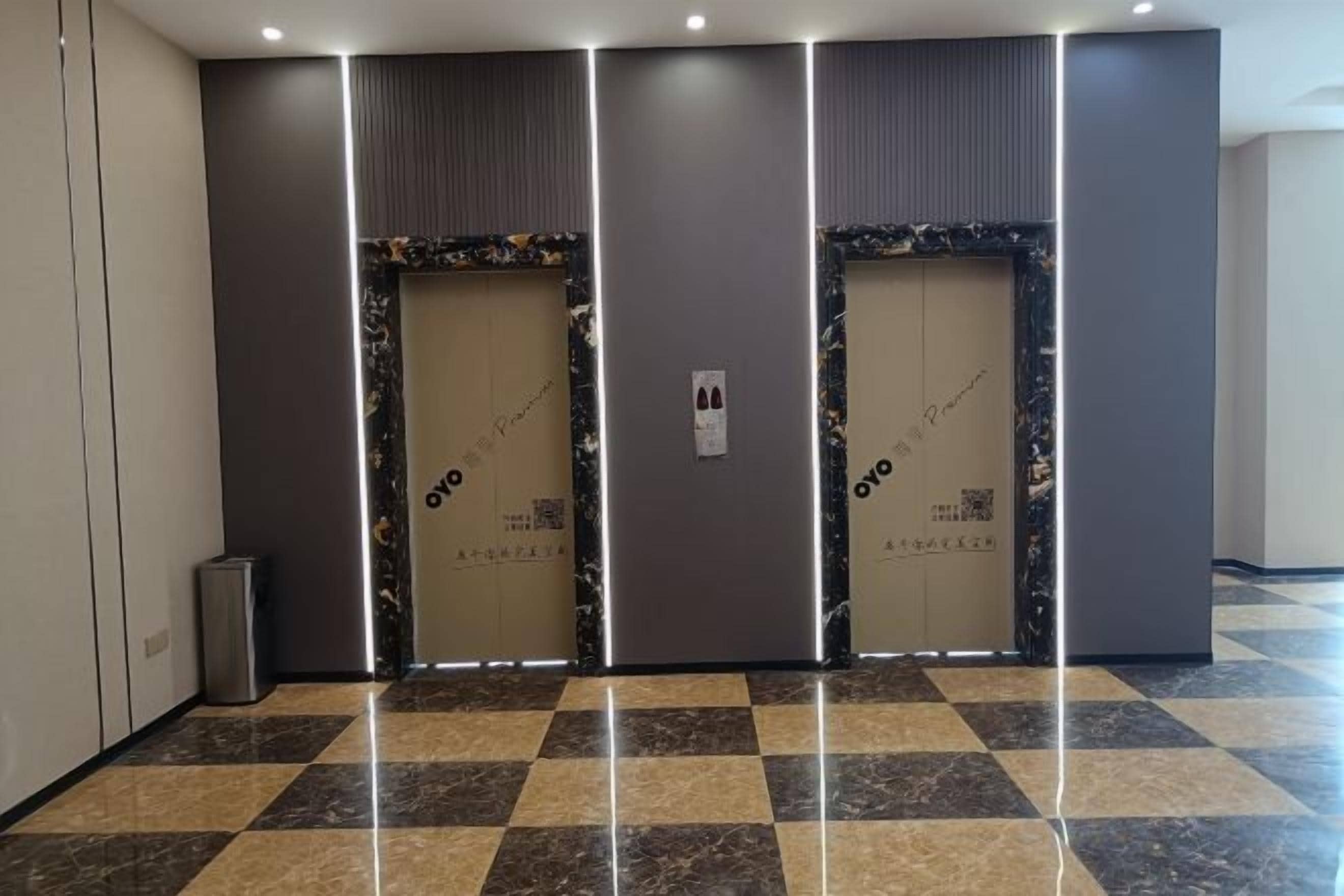 A hallway with two doors, each with a QR code and a sign indicating 'OYO'.