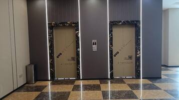 A hallway with two doors, each with a QR code and a sign indicating 'OYO'.