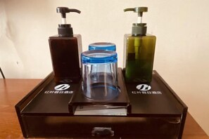 A black box with three bottles of liquid soap on top. - Hongye Holiday Hotel (Shuifu)