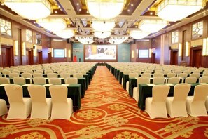 A conference room with rows of chairs, a carpeted floor, and a projection screen at the front. - Yichun Grand Metropark Resort (Yichun)