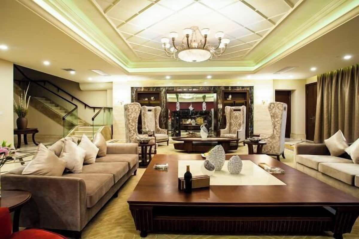 A spacious living room with a large coffee table, sofas, and a chandelier.
