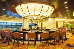 A bar area with a circular bar, multiple bar stools, and a central light fixture. - Yichun Grand Metropark Resort (Yichun)
