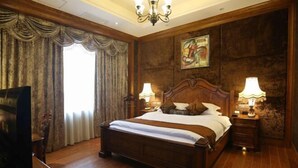 A hotel room with a large bed, two bedside lamps, a painting on the wall, and a television on a stand. - Minghao Hotel (Chongqing)