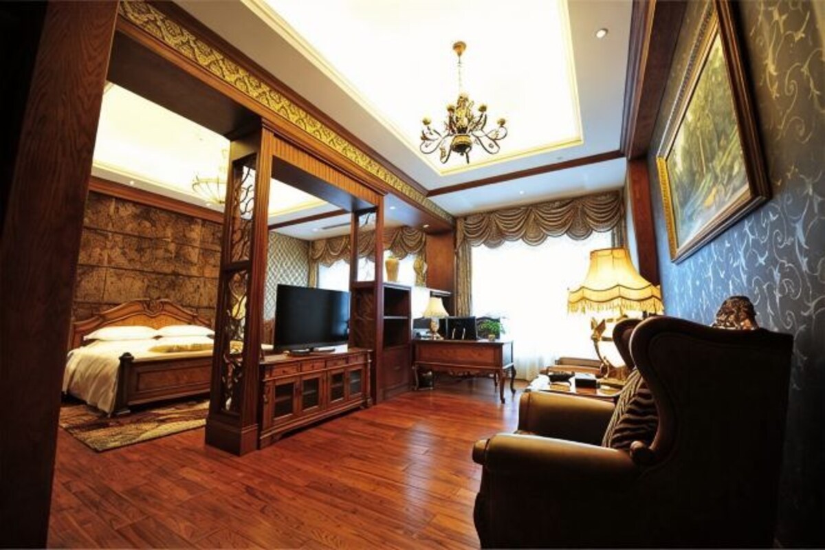 A room with a bed, TV, and seating area.