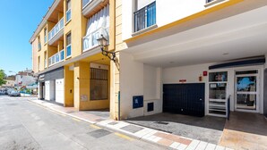 A building with a yellow facade, a gated entrance, and a blue door.