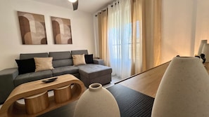 A modern living room with a grey sectional sofa, a wooden coffee table, and a white vase.