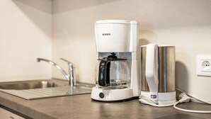 Eine Küche mit Kaffeemaschine, Spüle und Steckdose.