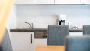 Eine moderne Küche mit Geschirrspüler von Siemens, einer Kaffeemaschine und einem Spülbecken.