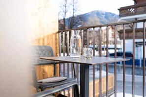 Un balcon avec une table, une chaise et un vase.