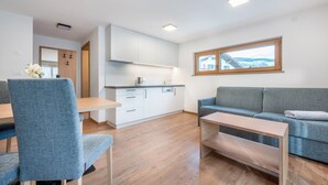 Una sala moderna con un sofá y un comedor con sillas y una mesa.