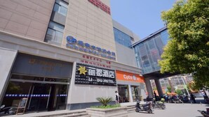 Un hotel con un letrero que dice 'Li Du Hotel' y una tienda 'Coco'.