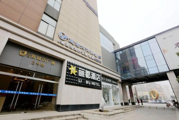 A hotel with a modern facade, a prominent entrance, and a visible outdoor seating area.