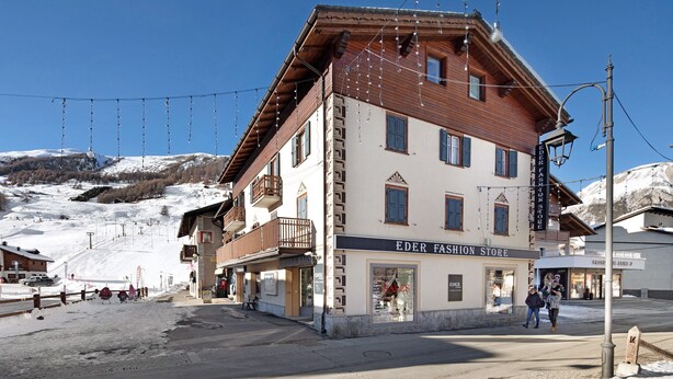 Un bâtiment avec une enseigne indiquant « EDER FASHION STORE » et un balcon.