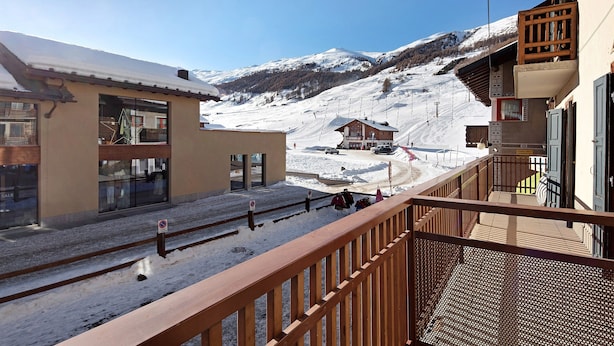 A snow-covered mountain landscape with a wooden building and a modern structure with large windows. - Gg 2 Apartment – Central Livigno, Gold Discount Card for Local Services Included (Livigno)