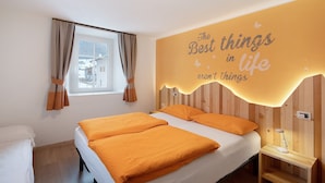 A hotel room with a bed, a bedside table, a window with curtains, and a wall with a motivational quote. - Gg 2 Apartment – Central Livigno, Gold Discount Card for Local Services Included (Livigno)