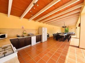 A spacious kitchen with a dining area, a built-in oven, and a refrigerator. - Villa "Casa Emilia" with Pool, Garden and Wi-Fi (Moraira)