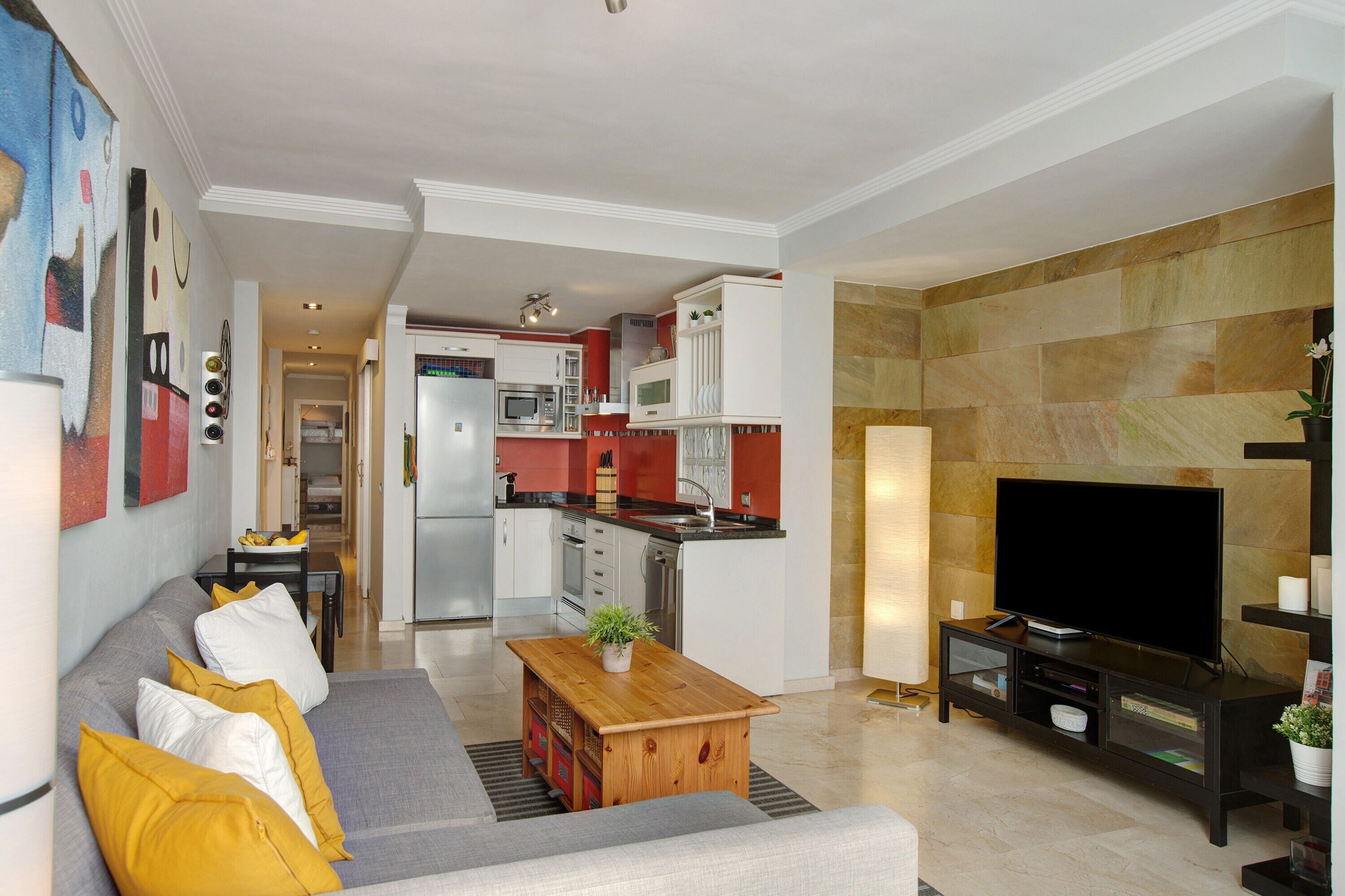 Una sala moderna con sofá, mesa de centro y mueble para televisor.