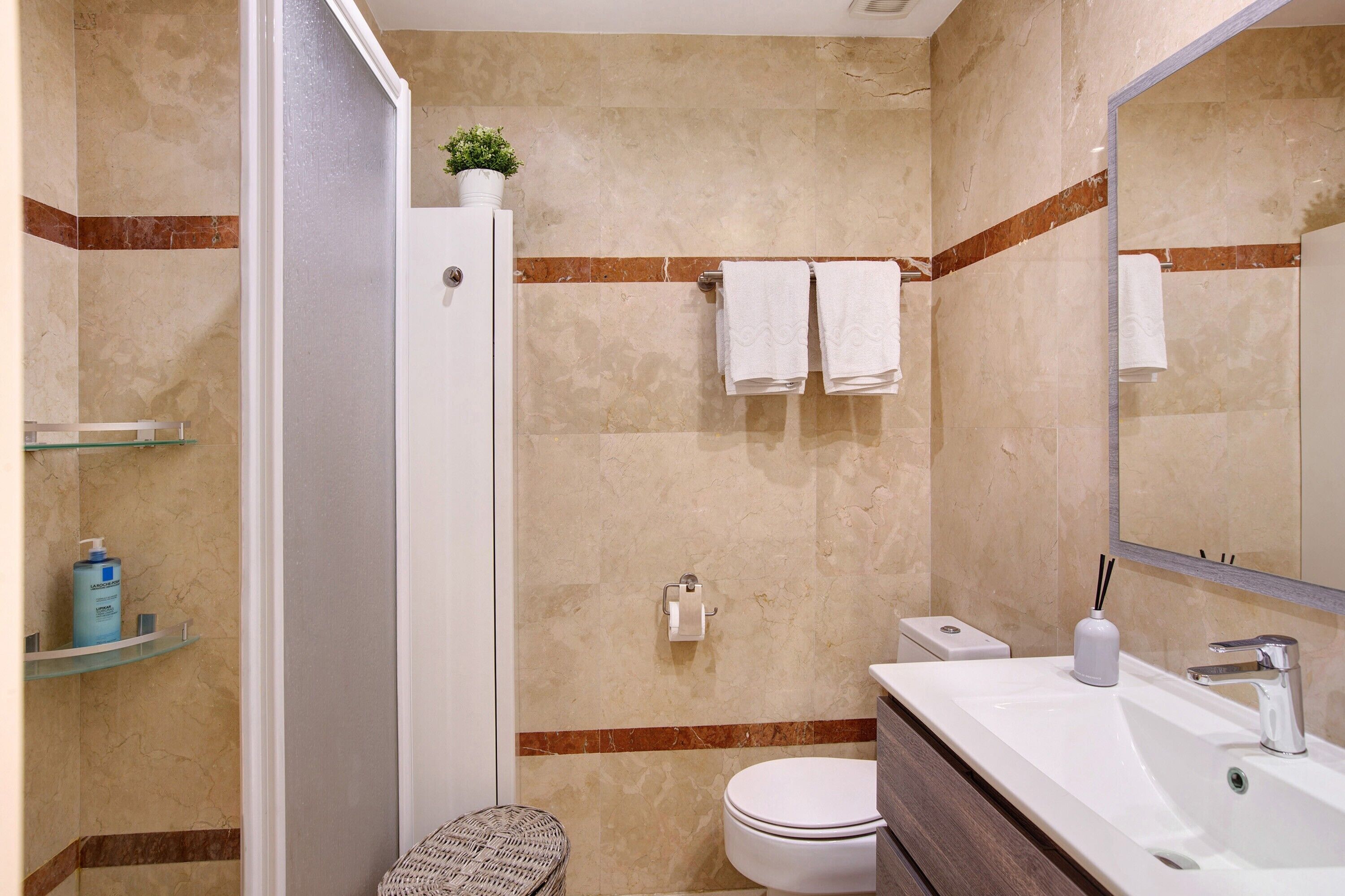 A bathroom with a toilet, sink, and shower.