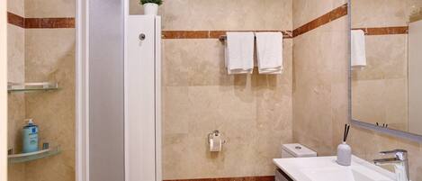 A bathroom with a toilet, sink, and shower.