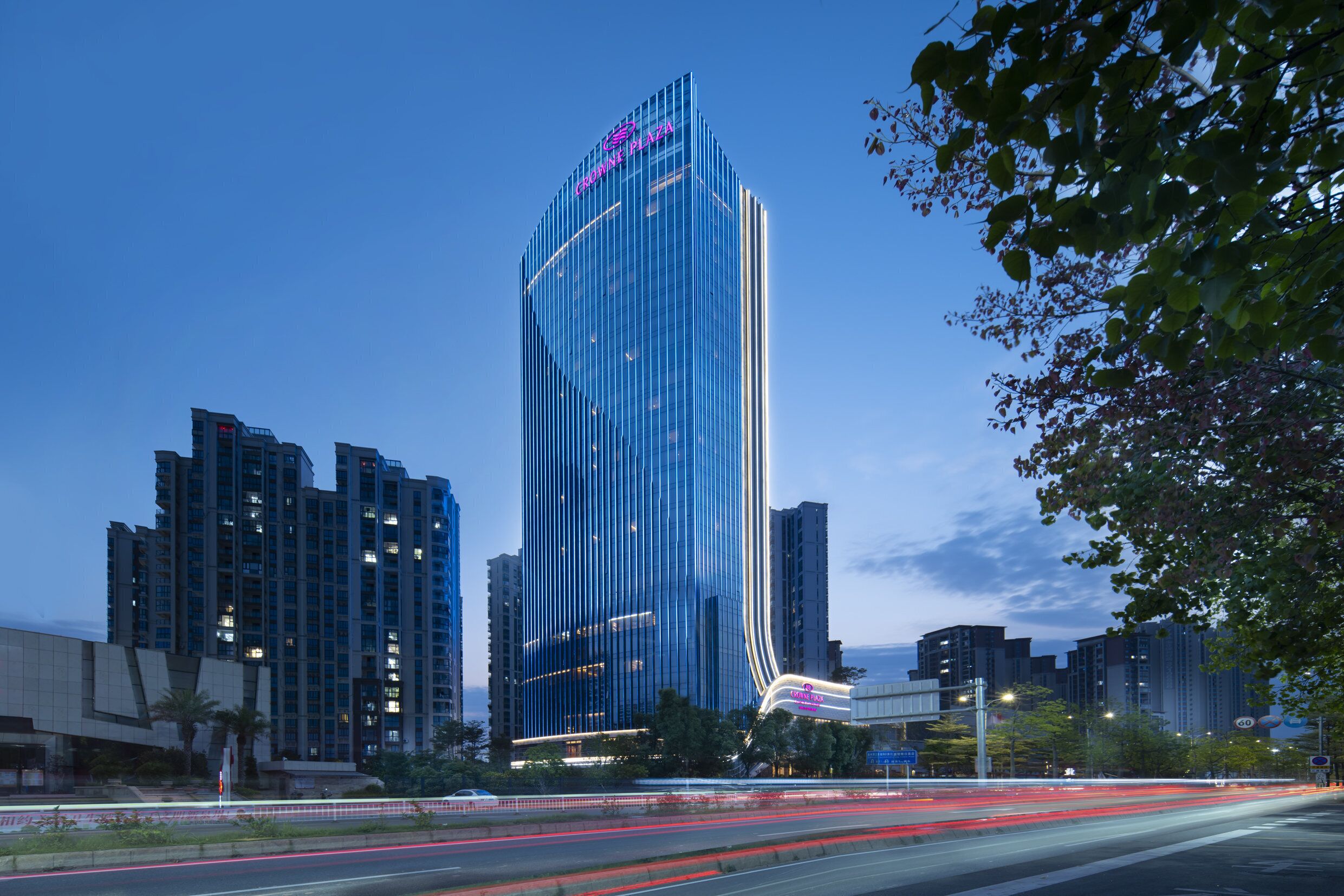 A high-rise building with a modern glass facade and a prominent sign at the top.