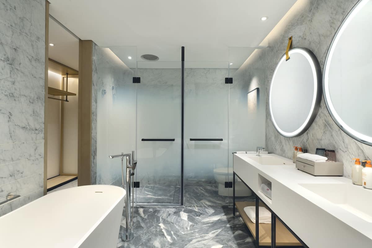 A modern bathroom with a freestanding bathtub, a glass-enclosed shower, and a vanity with a mirror.