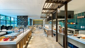 A modern restaurant with a buffet, bar seating, and a kitchen area. - Crowne Plaza Quanzhou Riverview by IHG (Quanzhou)