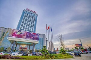 A hotel with a prominent tower, multiple flags, and a large billboard.
