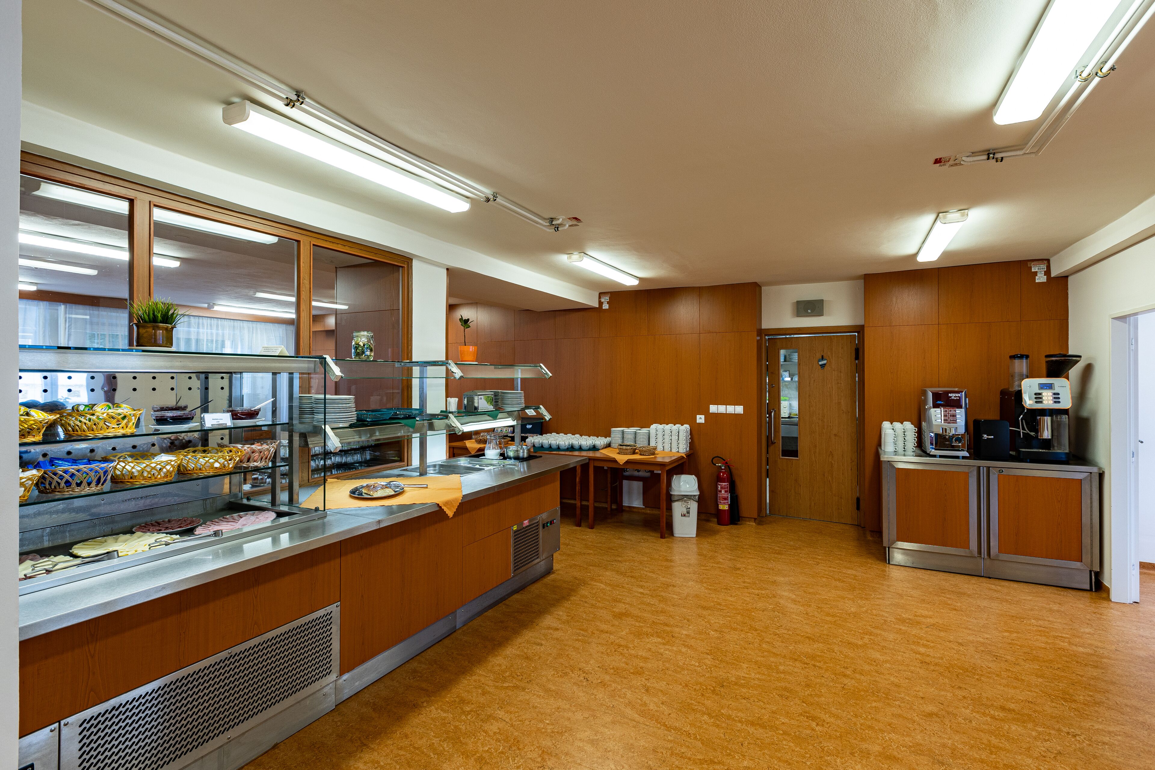 A spacious kitchen with wooden cabinets, a stainless steel counter, and a coffee machine.