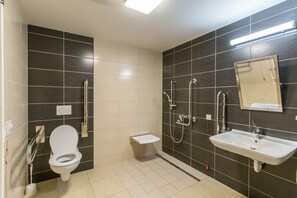 A modern bathroom with a toilet, sink, and shower.