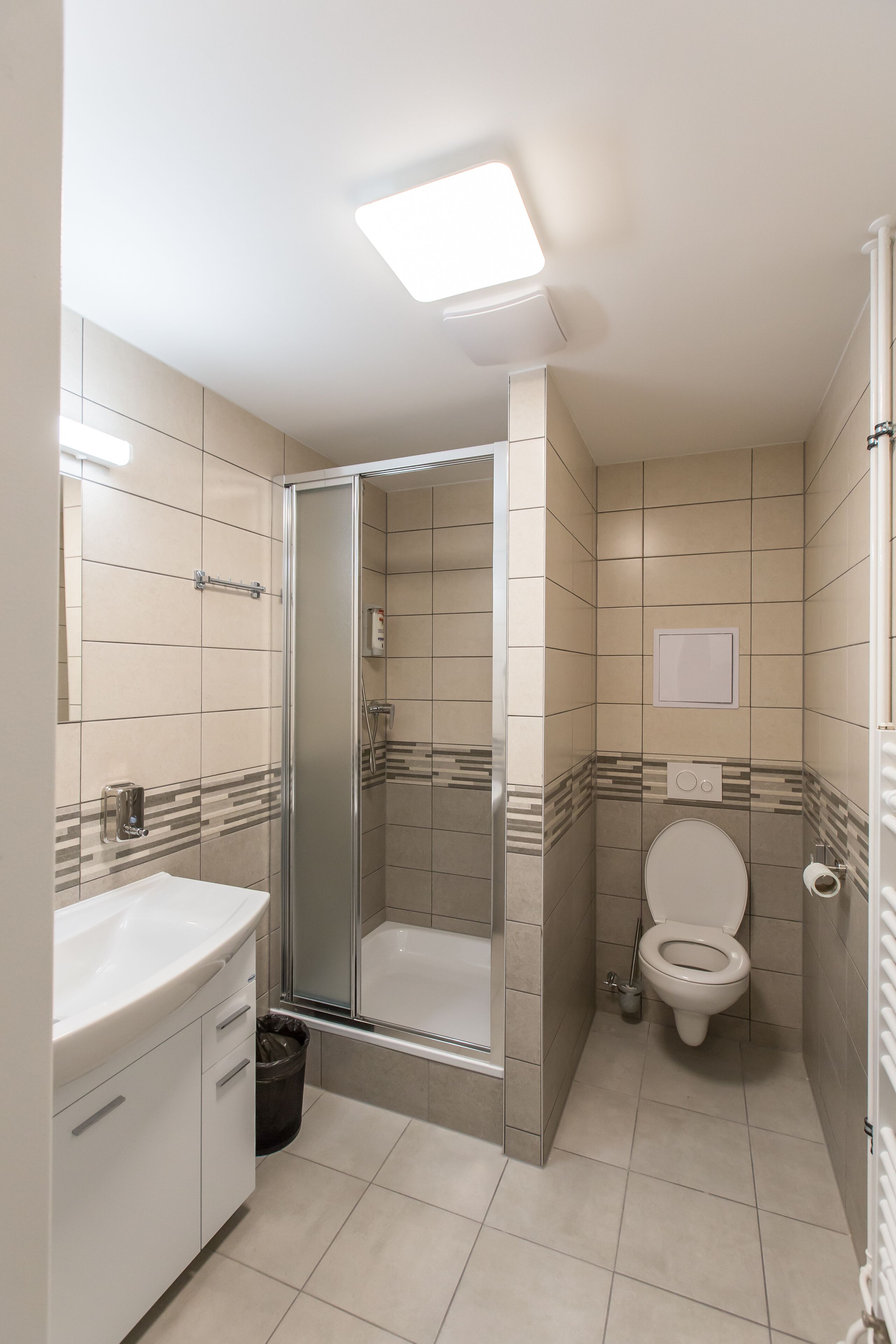 A bathroom with a shower, toilet, and sink.