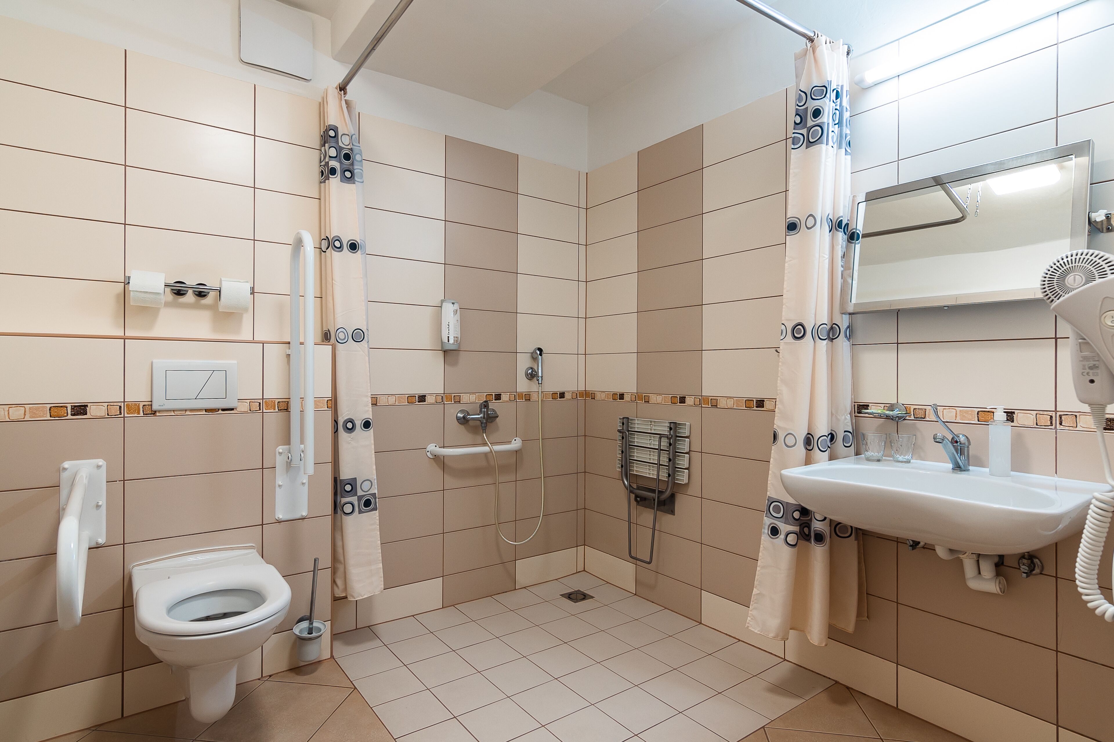 A bathroom with a toilet, shower, and sink.
