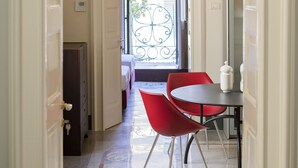 A hallway with a door leading to a balcony, a small table with a white pitcher, and red chairs. - Calendula - Design apartment in historic building 5 min from Lecce (San Cesario di Lecce)
