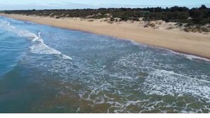 A beach with waves approaching the shore.