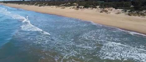 A beach with waves approaching the shore.