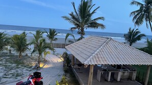 A beachside property with a covered patio, a red ATV, and palm trees. - Glass lacquer! Jacuzzi on the sand with gourmet area! (BA)