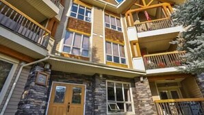 A multi-story house with a stone facade, multiple balconies, and large windows. - Sable Ridge View Suite -  Fireplace - Pool - A/C. (Radium Hot Springs)