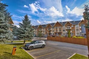 A multi-story residential building with a parking lot and a car parked in front. - Sable Ridge View Suite - Fireplace - Pool - A/C. (Radium Hot Springs)